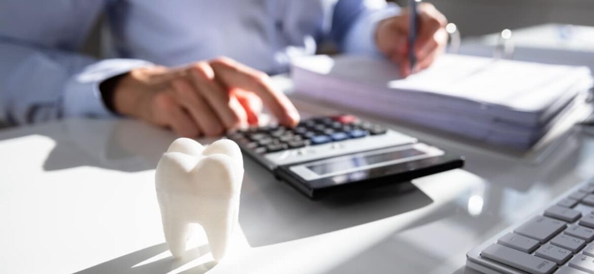 Close-up,Of,Tooth,In,Front,Of,Businessperson,Calculating,Bill